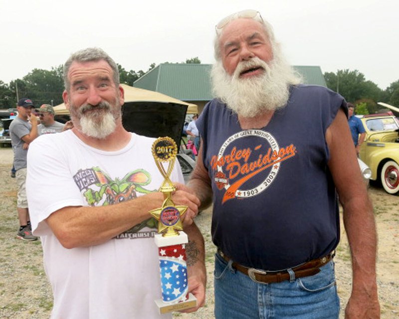 Bruce McCreery, right, of Bella Vista, won the trophy for best of show in the annual Gravette Day car, truck and bike show with his 1993 Harley Sportster motorcycle. Fifty entrants competed in this year's show.