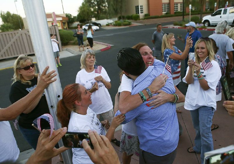 Eric Parker gets a hug after he and another defendant in a 2014 standoff were released Tuesday in Henderson, Nev., when a jury failed to reach a verdict on their charges. 