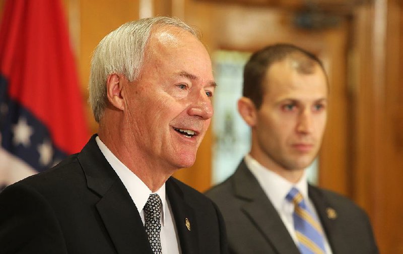 Arkansas Governor Asa Hutchinson (left) is shown with Mike Preston, executive director of the Arkansas Economic Development Commission, during a press conference at the state capitol, June 14, 2017.