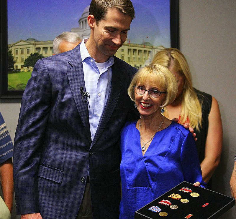 U.S. Sen. Tom Cotton hugs Charlotte Garlington after presenting her family with military medals for her father, George Anderson, at Cotton’s Little Rock office Wednesday. Anderson, a World War II veteran, died in 2006.
