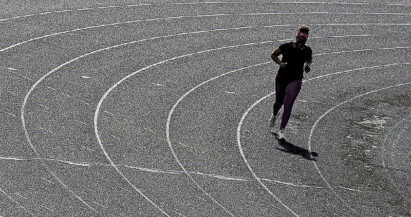 Arkansas Democrat-Gazette/JOHN SYKES JR. - A woman jogs around the Scott Field track in Little Rock Wednesday morning on a mostly cloudy day in central Arkansas.