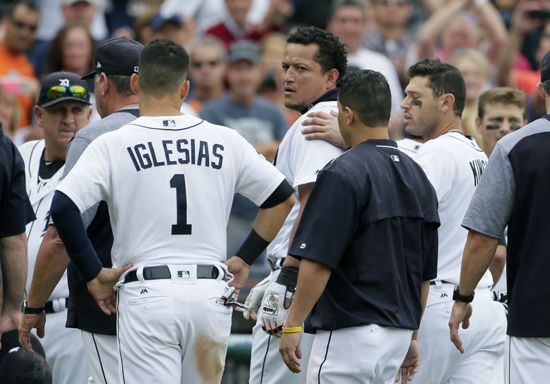 Detroit Tigers' Miguel Cabrera looks back at the New York Yankees as he is guided off the field by teammate Ian Kinsler, right, and Jose Iglesias (1) following a bench-clearing fight during the sixth inning a of a baseball game Thursday, Aug. 24, 2017, in Detroit. 