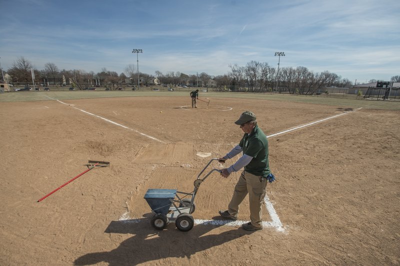 NWA Democrat-Gazette/ANTHONY REYES Bobby Hinton, with the Bentonville Parks and Recreation department, lays chalk lines Friday, Feb. 10, 2017 at the softball fields at Memorial Park in Bentonville. Visiting Bentonville will improve the fields at the park and add artificial turf infields.