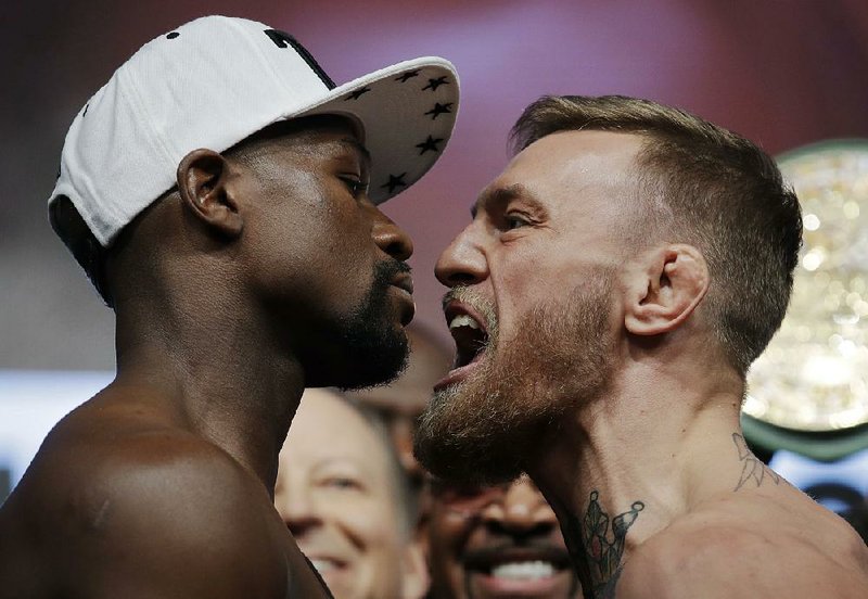 Floyd Mayweather Jr. (left) and Conor McGregor square off Friday in Las Vegas during the weigh-in for tonight’s fight. Interest appears high for the ÿght between the former boxing champion (Mayweather) and the MMA star.