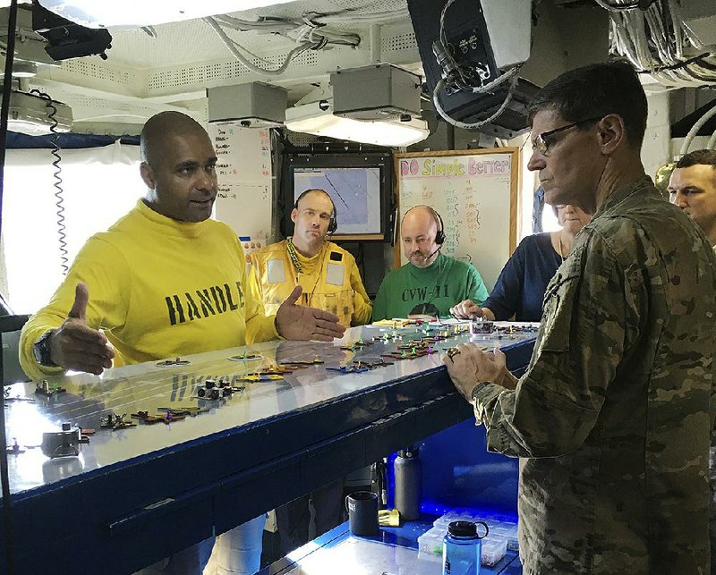 G en. Joseph Votel, the top U.S. commander for the Middle East (right), gets a briefing aboard the USS Nimitz from Lt. Cmdr. Vern Jensen on Thursday.     