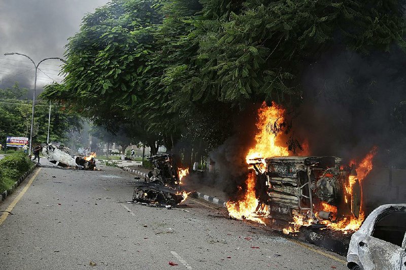 Vehicles burn Friday during rioting in Panchkula, India, by supporters of a sect leader found guilty of rape.