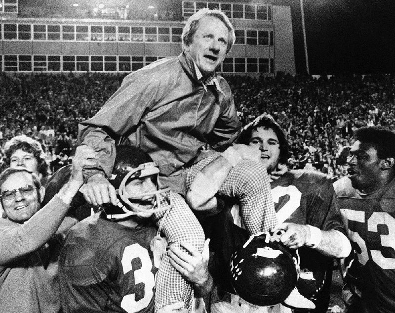 FILE - In this Dec. 6, 1975, file photo, Arkansas coach Frank Broyles is carried from the field by players Teddy Barnes, left, and Richard LaFargue (52) following his team's 30-6 NCAA college football game victory over Texas A & M in Little Rock, Ark. 