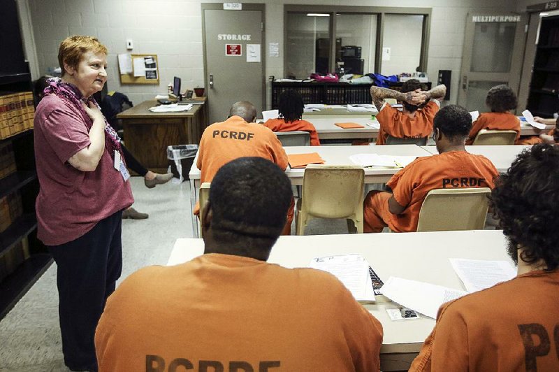 Kathy Rateliff (left), a volunteer with Westover Hills Presbyterian Church’s outreach initiatives, discusses a reading exercise with inmates at the Pulaski County jail.