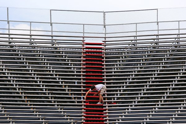 Park Specialist Michael Flake puts a fresh coat of paint on the bleachers at War Memorial Stadium in Little Rock on Wednesday, June 21, 2017.
