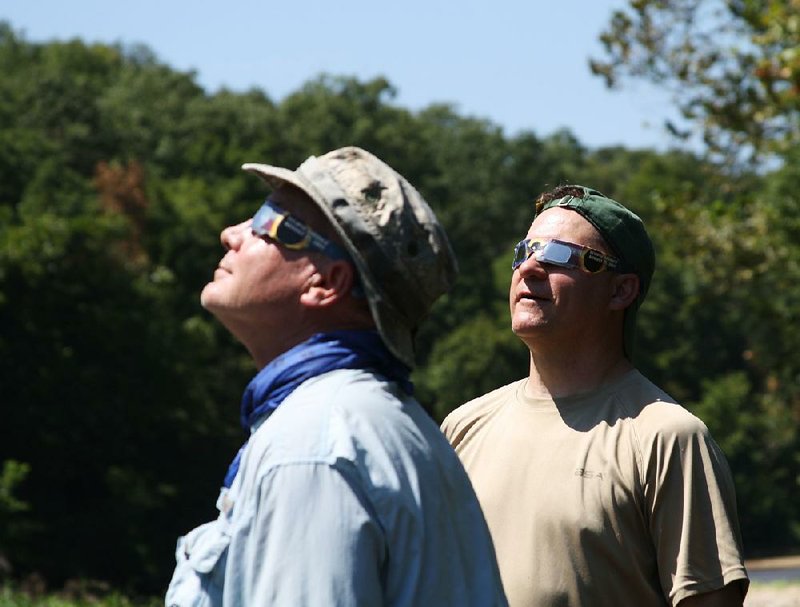 Rusty Pruitt (left) and Bill Eldridge gaze at the solar eclipse Monday while trout fishing on Crooked Creek.The Eclipse Celebration resulted in slow fishing but many memories.