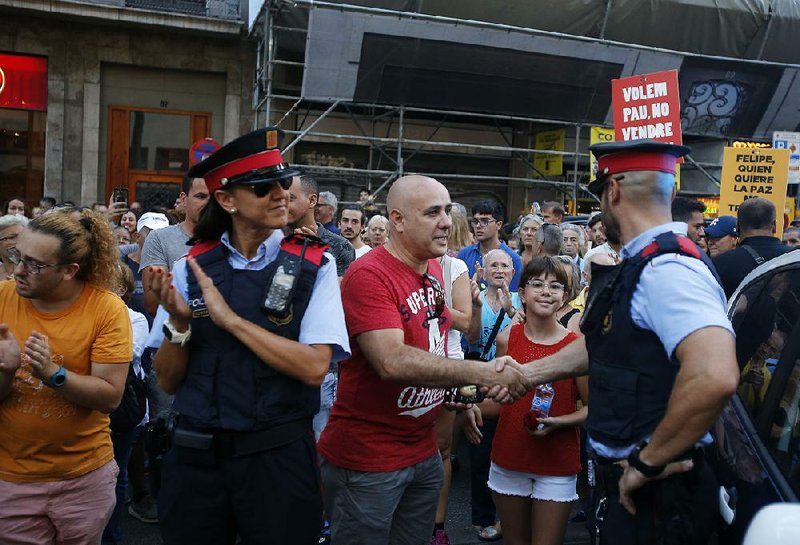 A marcher  thanks a police officer Saturday  in Barcelona after a demonstration condemning this month’s attacks in Spain.