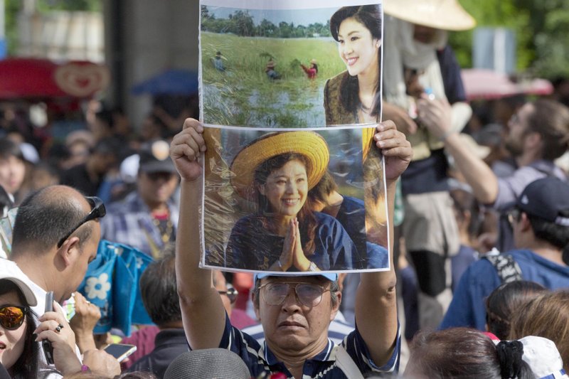 Supporters of Thailand's former Prime Minister Yingluck Shinawatra display her images outside the Supreme Court after Yingluck failed to show up to hear a verdict in Bangkok, Thailand, Friday, Aug. 25, 2017. 