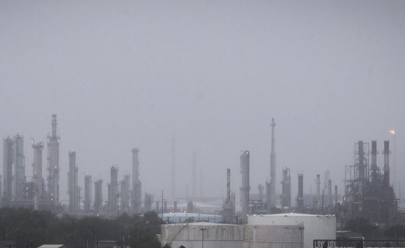 An oil refinery flare, right, continues to burn through wind and rain as Hurricane Harvey moves into Corpus Christi, Texas, on Friday, Aug. 25, 2017. Hurricane Harvey is expected to make landfall on the Texas coast Friday night or early Saturday morning. 