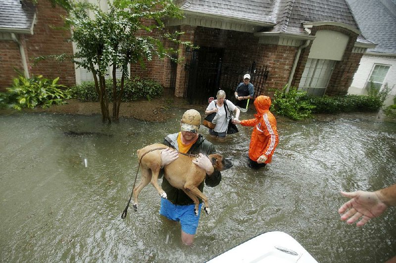 Volunteers help a family get out of their home Monday in a Houston neighborhood inundated by floodwaters. Federal Emergency Management Agency officials said Monday that the response to Harvey is “quickly drawing down” its disaster fund of more than $3 billion.