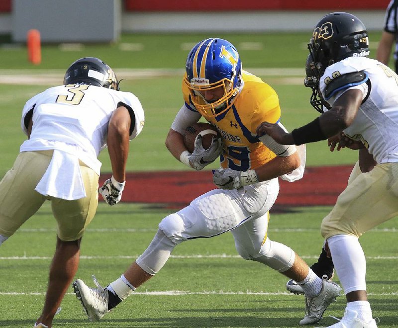 Joe T. Robinson defenders Nathan Page (left) and Chris Carvill (right) move in to tackle Hot Springs Lakeside’s Michael James Monday night during the season-opener for both teams at War Memorial Stadium in Little Rock. Page was all over the field, intercepting two passes, returning one for a touchdown. He also caught a touchdown pass, but was ejected from the game with 2:38 remaining in the third quarter after being flagged for unsportsmanlike conduct for the second time.