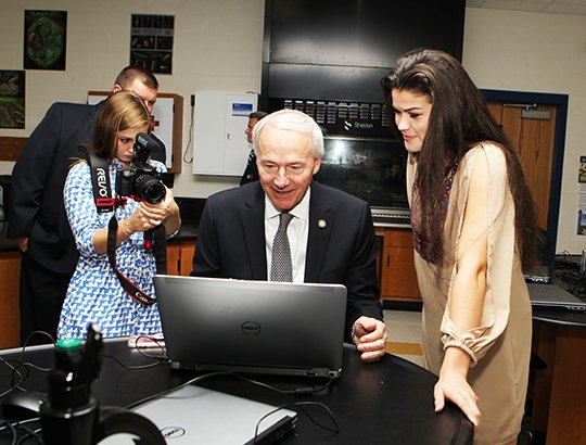 The Sentinel-Record/Richard Rasmussen COMPUTER SCIENCE: Gov. Asa Hutchinson, center, learned about a math for kids program created by Emma Ferguson, right, during his visit to Lakeside High School Monday. Fellow Lakeside student Hannah Whorton helped film the visit for the school's broadcasting program, which was highlighted by the governor and his office.