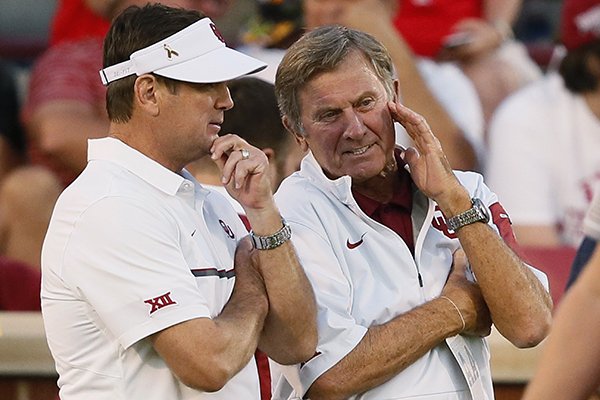 Oklahoma coach Bob Stoops, talks with former Florida coach Steve Spurrier before an NCAA college football game between Ohio State and Oklahoma in Norman, Okla., Saturday, Sept. 17, 2016. (AP Photo/Sue Ogrocki)
