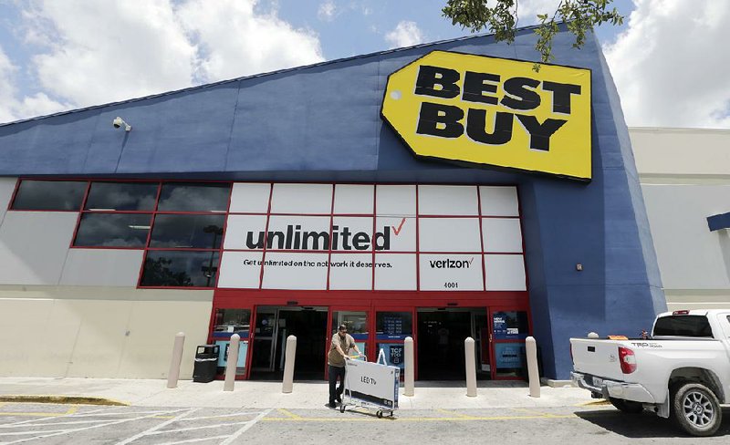 A Best Buy customer exits a store in Hialeah, Fla., in this May photo. The retailer on Tuesday reported a quarterly profit of $209 million. 