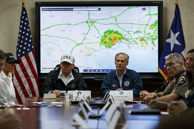 President Donald Trump attends a briefing on relief efforts Tuesday with Texas Gov. Greg Abbott at the Texas Department of Public Safety Emergency Operations Center in Austin. 