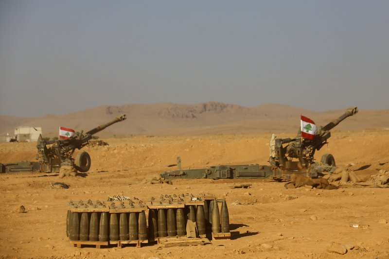 Lebanese national flags are set on the top of cannons inside a base during a media trip organized by the Lebanese army, on the outskirts of Ras Baalbek, northeast Lebanon, Monday, Aug. 28, 2017. Lebanon's Hezbollah TV is reporting that Islamic State militants started leaving the border area with Syria on Monday as part of a negotiated deal to end the extremist group's presence there. (AP Photo/Hassan Ammar)