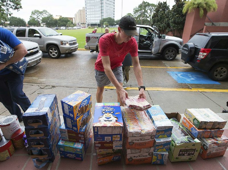 Volunteers unload donations Wednesday outside the Lake Charles, La., Civic Center, where flooding evacuees from Texas and Louisiana are being housed.