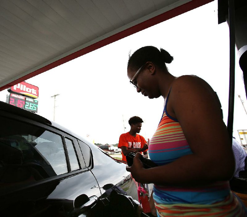 Crystal Johnson of Oklahoma City fills up Wednesday at the Pilot Travel Center on Interstate 40 in North Little Rock. She and her children were on their way to Georgia. 