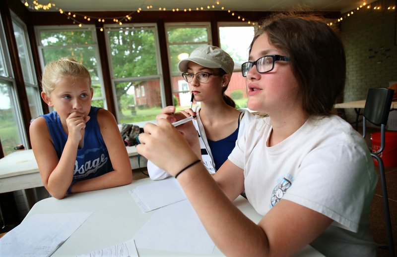 NWA Democrat-Gazette/DAVID GOTTSCHALK Sydnie Johnson (from left), Lily Clifton and Emma Holt discuss their work in June at the Apple Seeds Teaching Farm at Gulley Park in Fayetteville. An "Evening at the Farm" at 5:30 p.m. Oct. 7, will benefit the nonprofit teaching farm.