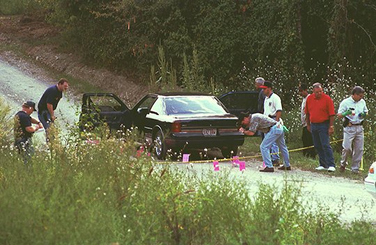 The Sentinel-Record/File photo COLD CASE: Garland County sheriff's investigators, Arkansas State Police and the Arkansas Medical Examiners collect evidence from the scene of a brutal double homicide on Aug. 31, 1997, on Hayti Lane, located just off Bald Mountain Road. The case remains unsolved 20 years later, but investigators are still hoping to bring the killers to justice.