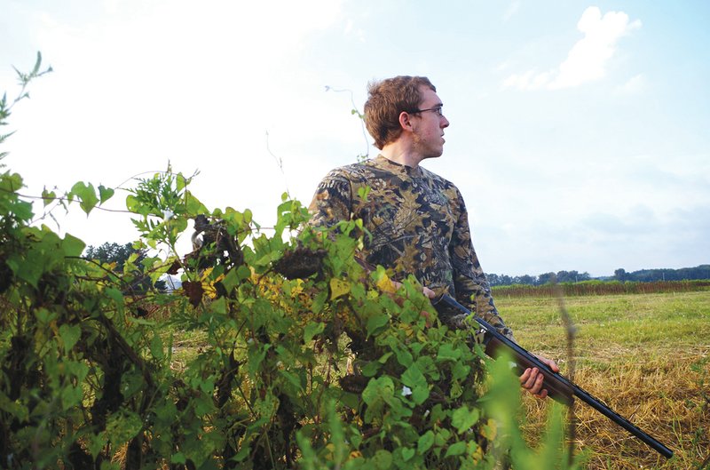 Watching dove activities in a field prior to picking a stand, like Zach Sutton of Alexander is doing here, can help a hunter pinpoint the best spot in a field to take good shots at passing or incoming doves.