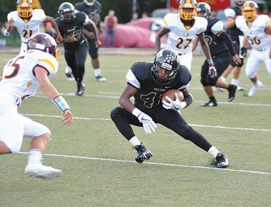 The Sentinel-Record/Mara Kuhn RIVALRY RENEWED: Hot Springs fullback Rashad Wells looks for yardage against Lake Hamilton last season at Reese Memorial Stadium. The Trojans and Wolves will renew their crosstown rivalry in the season opener for both teams tonight on Bank of the Ozarks Field at Wolf Stadium.