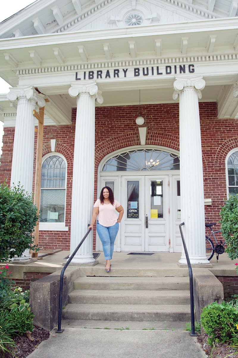Danella Metcalf, children’s librarian, stands next to one of the original ionic columns on the front of the Clark County Library in Arkadelphia, which was built in 1903. The column at the far left is in need of immediate repair, which will be done with grant money received from the Arkansas Historic Preservation Program. Ashley Graves, library director, said the grant will also pay for repairing the roof.