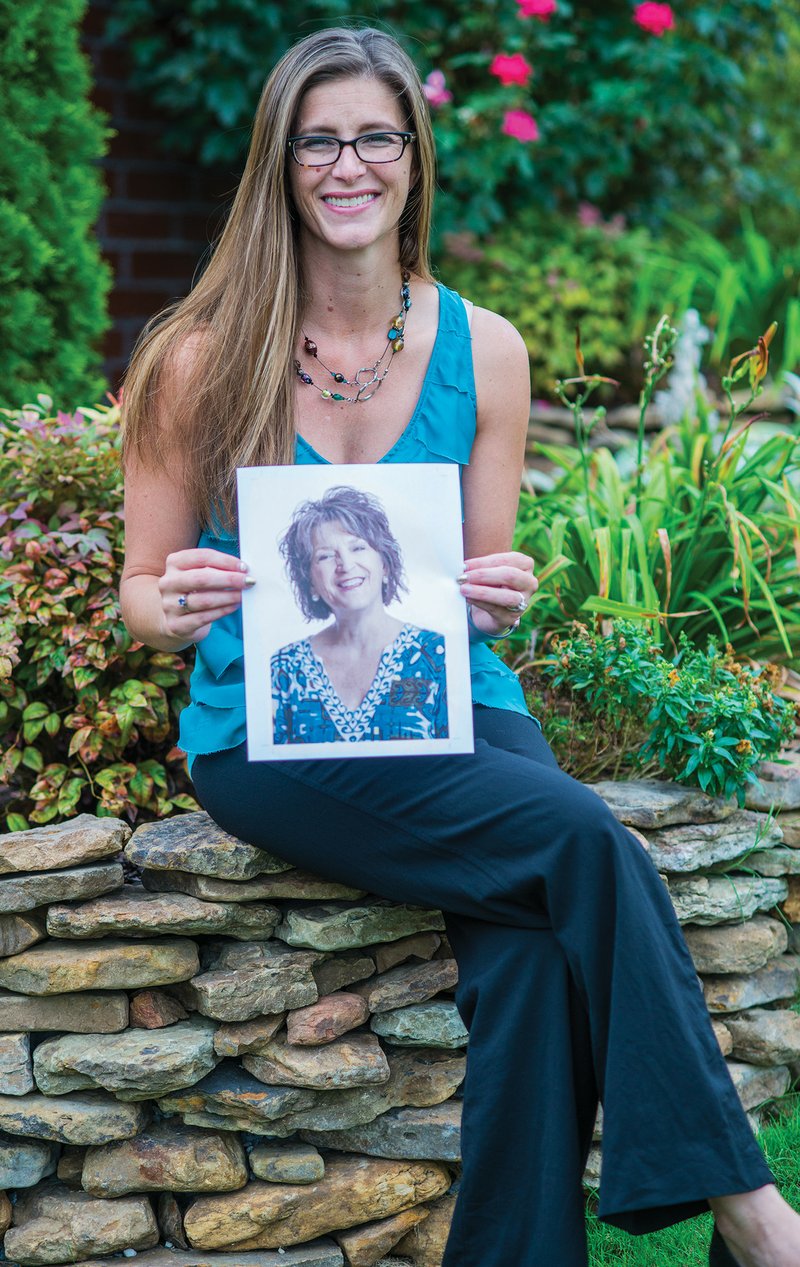 Amy Lasseigne of Maumelle holds a photograph of her mother, Suzanne Holland, who died in 2016 of ovarian 
cancer. Lasseigne and her mother, along with two other women, founded the Arkansas Ovarian Cancer Coalition in 2009 to bring awareness to the silent symptoms of the disease. It is holding its annual fundraiser, TEAL Light Night from 7-10:30 p.m. Friday at the Clinton Presidential Center in Little Rock. September is National Ovarian Cancer Awareness Month.