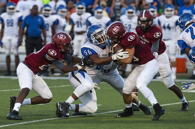 Conway’s Tyrell Grimes (56) stops Springdale’s Alex Thompson during the second half of Friday night’s game in Springdale. Thompson fumbled on the play and Conway recovered.