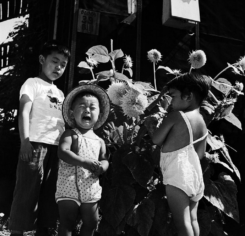 A crying child and friends were photographed by Paul Faris, Hendrix College photography and English teacher, at the Rowher Relocation Center in July 1945. It hangs in the exhibition “The Art of Injustice: Paul Faris’s Photographs of Japanese Incarceration Rohwer, AR, 1945” at the Butler Center for Arkansas Studies.