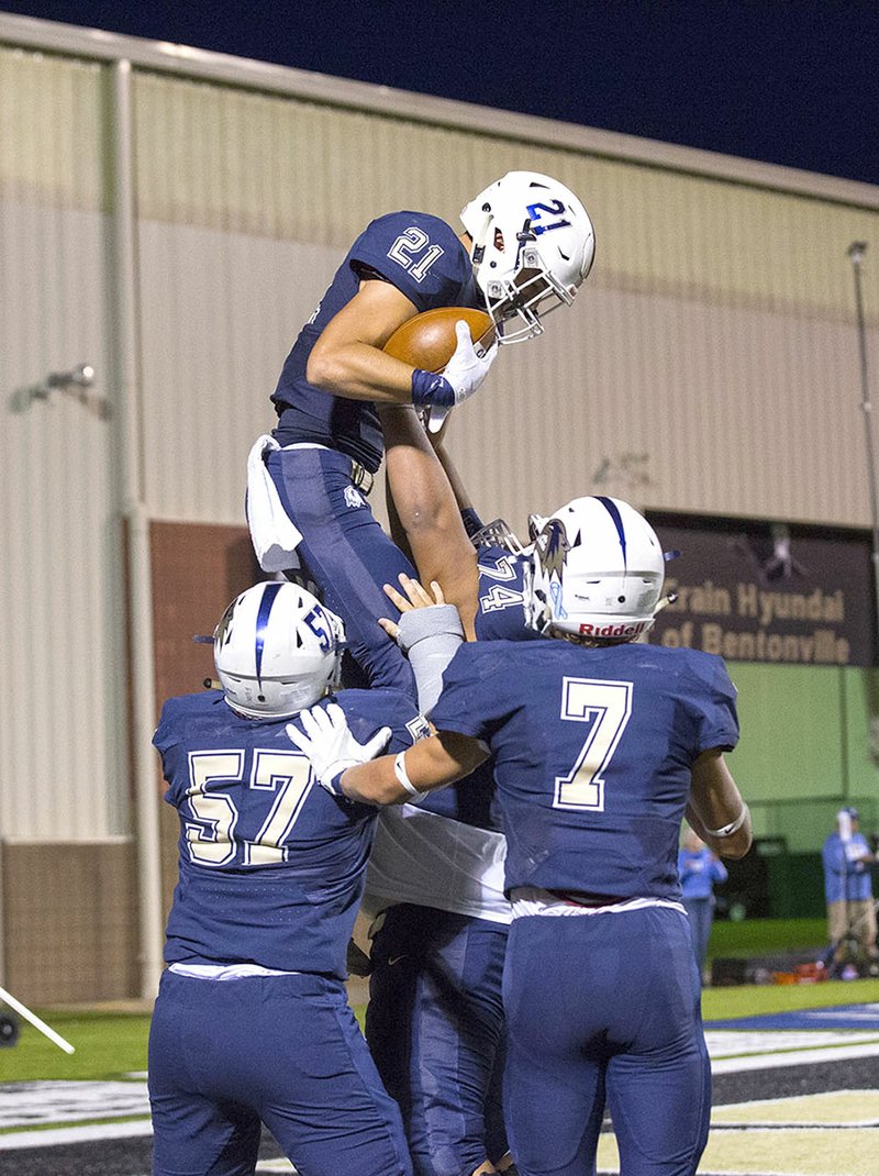 Special to NWA Democrat-Gazette/DAVID BEACH Bentonville West's Jonas Higson (21) celebrates with his teammates Friday after scoring a touchdown against Pryor, Okla., at Tiger Stadium in Bentonville.