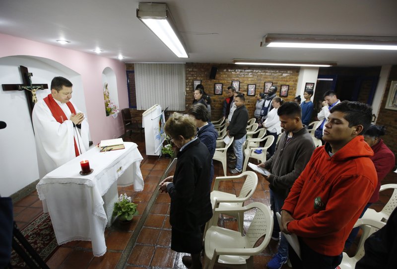 In this Aug. 24, 2017 photo, a priest celebrates Mass for Venezuelan refugees living at the Center for Migrants run by Scalabrinian nuns in Bogota, Colombia. 