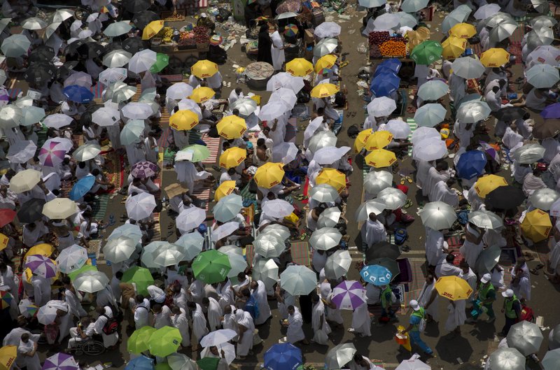 Muslim pilgrims hold umbrellas as they attend noon prayers outside the Namirah mosque on Arafat Mountain, during the annual hajj pilgrimage, outside the holy city of Mecca, Saudi Arabia, Thursday, Aug. 31, 2017. 