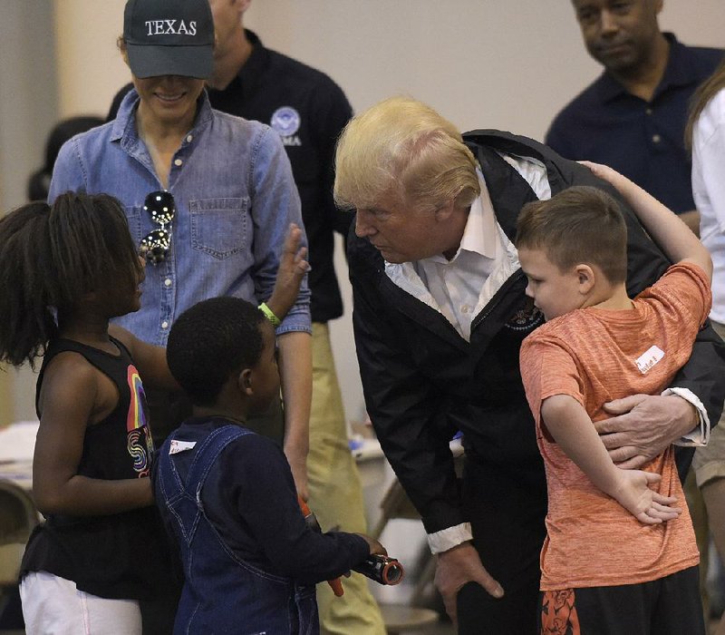 President Donald Trump and his wife, Melania, visit with children Saturday at Houston’s NRG Center, a convention center serving as a temporary shelter for storm victims. “There’s a lot of love. As tough as it’s been, it’s been a wonderful thing to watch,” Trump said. 
