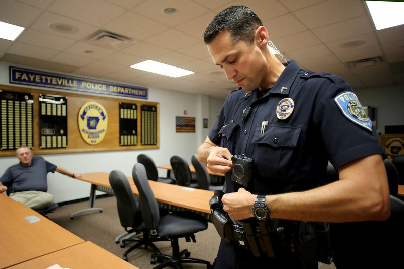 Cpl. Stephen Mauk with Fayetteville’s Police Department secures a body camera Thursday to his uniform chest at the station in Fayetteville. Fayetteville police just arranged a $762,000 five-year contract with Axon Enterprises of Tucson, Ariz., to get body cameras for all its officers. The City Council will vote on the contract Tuesday.