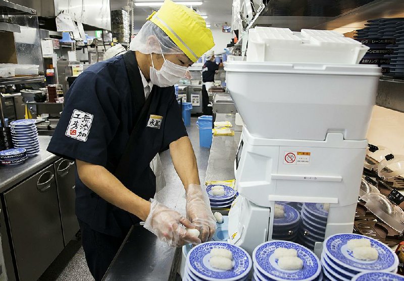 A chef prepares sushi using Suzumo Machinery Co. equipment inside a Kura Corp. restaurant in Kaizuka, Japan. Suzumo’s machines are used by about 70,000 customers.