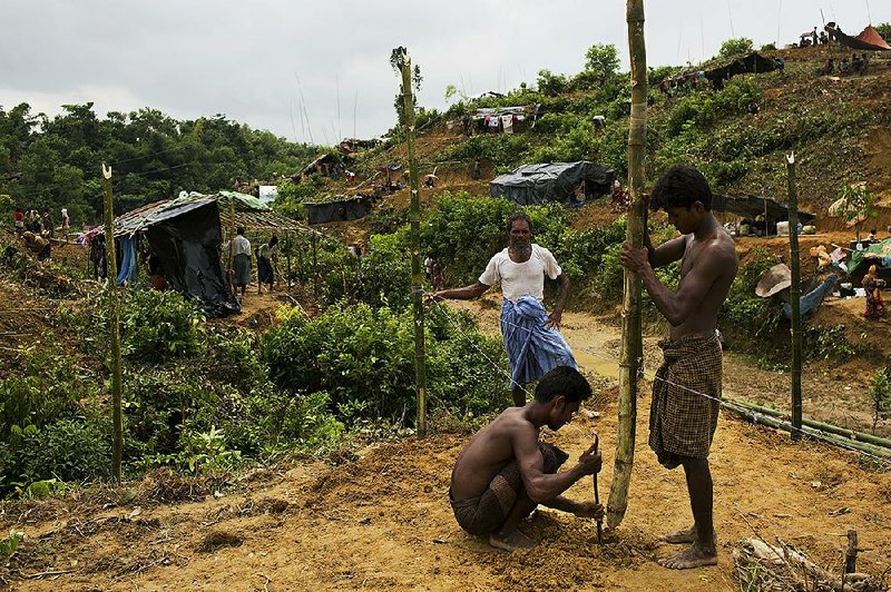 Rohingya fleeing violence in Burma use bamboo sticks to build a shelter Sunday near an area of Cox’s Bazar, Bangladesh.