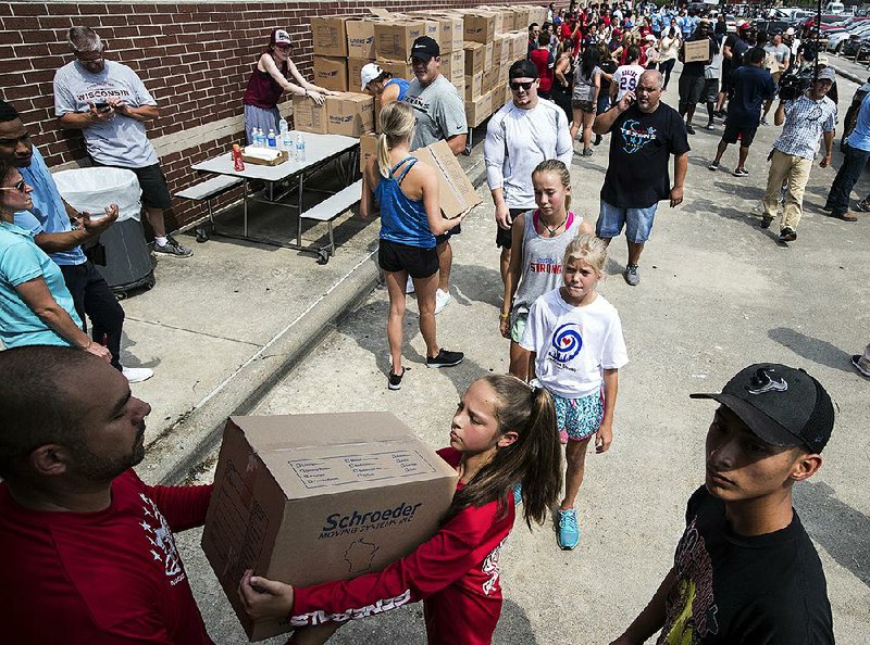 Volunteers in Houston unload a truck of relief supplies Sunday for people affected by Hurricane Harvey.