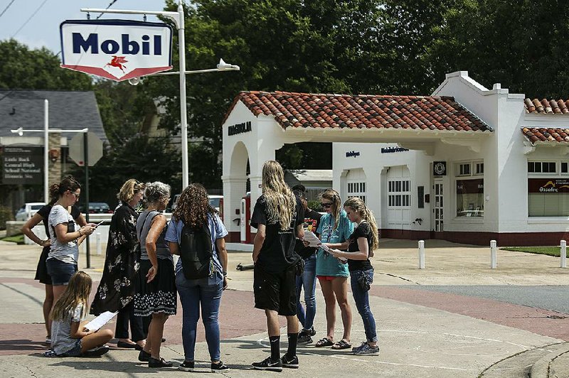 Visitors read off a script Monday during a walking tour that re-creates the first day in 1957 when the Little Rock Nine attempted to attend classes at Little Rock Central High School.