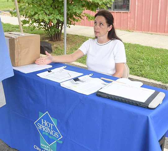 The Sentinel-Record/Mara Kuhn COMMUNITY MINDED: Michelle Sestili, who served as the city's Community Development Block Grant administrator since 2013, staffs a booth at the Community Resource Fair on Aug. 12 in the 100 block of Pleasant Street. Sestili, who is moving with her husband to Houston, left the position Friday.