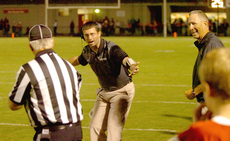 MARK HUMPHREY ENTERPRISE-LEADER Football intensity runs in the family. Farmington offensive coordinator Spencer Adams, son of head football coach Mike Adams (right) asks an official why no flag was thrown after a Cardinal ball carrier was brought down by his face mask during a 5A West game.