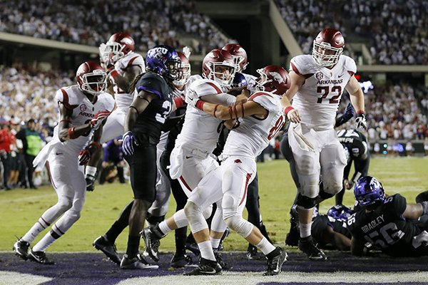 Arkansas quarterback Austin Allen, center, breaks into the end zone with help from Drew Morgan, center right, on a touchdown run against TCU in the Arkansas 41-38 double overtime win in an NCAA college football game, Saturday, Sept. 10, 2016, in Fort Worth, Texas. (AP Photo/Tony Gutierrez)

