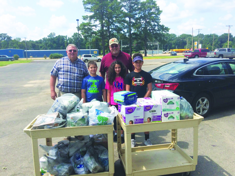 Area youths donate to hurricane victims
Ouachita County Judge Robert McAdoo, far left, stands with area youngsters Jarmacus Haynie, 9, La’kia Haynie, 11,  and Jamale Haynie, 13, after the youths collected and donated items needed by victims of Hurricane Harvey. The children worked 'odd jobs' to raise money for the supplies they donated to the victims. Also shown in the back row is Ouachita County Sheriff David Norwood. See article.