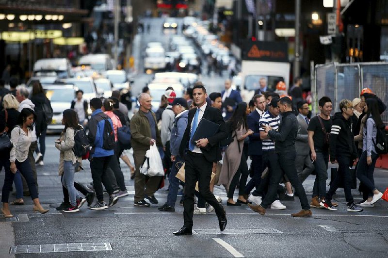 People move about the city Wednesday as the working day ended in Sydney. Population growth is seen as a hidden contributor to Australia’s economic success. 