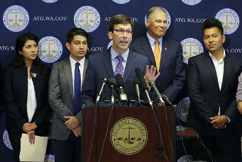Attorney General Bob Ferguson of Washington (center) and Washington Gov. Jay Inslee (second from right), joined by young people with deferred status, announce their part in the lawsuit Wednesday in Seattle. 