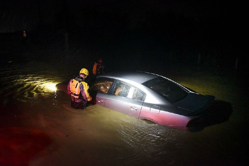 A rescue team investigates an abandoned car Wednesday night in Fajardo on the northeastern edge of Puerto Rico after Hurricane Irma struck with heavy rain and devastating winds. 